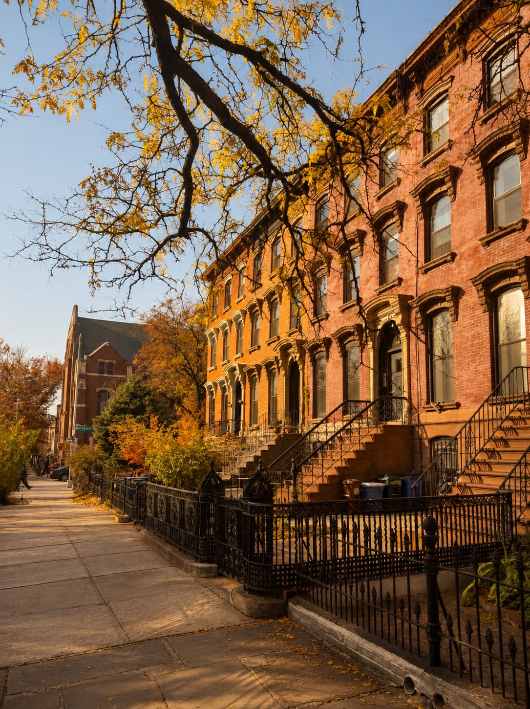 Macon Guesthouse, a red-brick Brooklyn brownstone on a tree-lined block in autumn